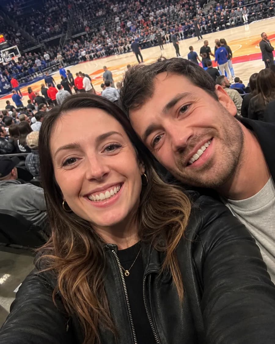 Elena and a friend taking a selfie from their seats at a basketball game